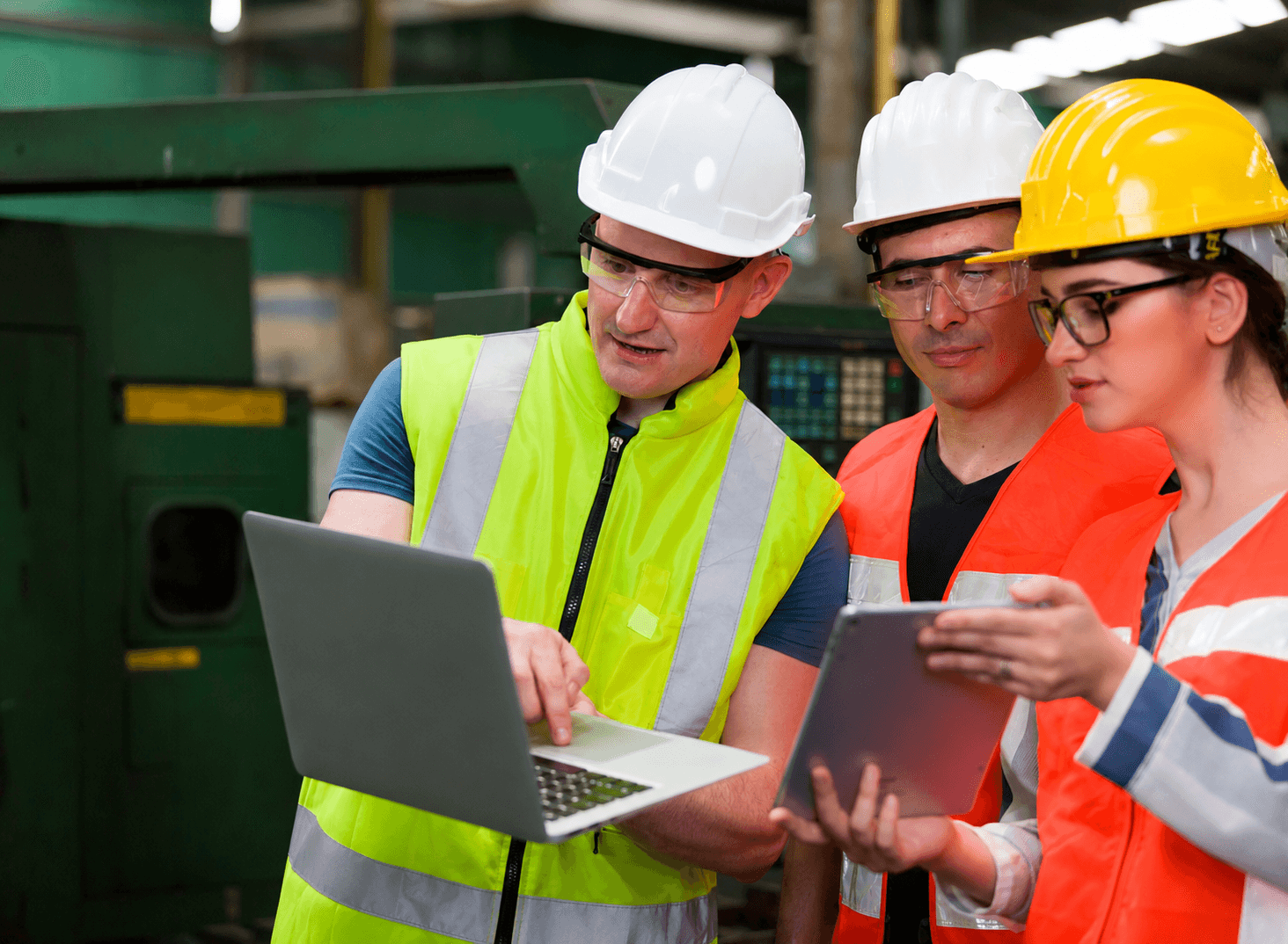Industrial engineer reviewing data pipelines on a laptop in a manufacturing facility